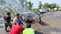 Sejumlah petugas SPBU dan petugas Damkar berjibaku memadamkan api yang membakar mobil.