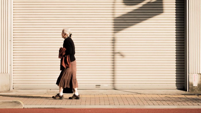 JAPAN, TOKYO - NOVEMBER 2016: An unidentified old woman walks along the roadside of Tokyo, Japan. Japans population is aging.