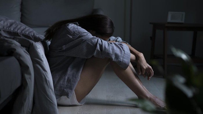 Young Asian woman in bedroom feeling sad tired and worried suffering depression in mental health