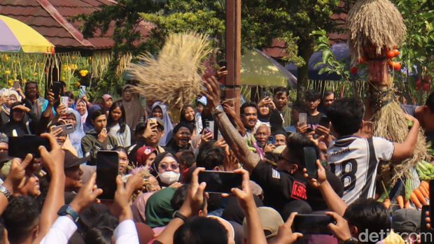 Sejumlah warga berebut gunungan hasil bumi saat puncak Grebeg Sura di kawasan lokawisata Baturraden, Kabupaten Banyumas, Minggu (12/7/2026).