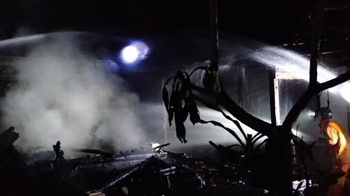 Petugas memadamkan api yang membakar rumah warga di Pekutatan, Jembrana, Sabtu (11/7/2026).