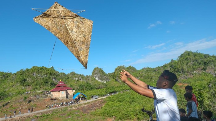Sejumlah peserta mengamati layang-layang Kaghati Kolope yang diterbangkan di Pelataran Lapego, Desa Liang Kabori, Kabupaten Muna, Sulawesi Tenggara, Minggu (12/7/2026). Pemkab Muna menggelar lomba layang-layang yang terbuat dari bahan daun ubi hutan (kolope) yang dirangkaikan dengan bambu dan tali dari serat buah nanas tersebut sebagai upaya menjaga tradisi dan menggaungkan kembali warisan leluhur kepada generasi muda di wilayah itu. ANTARA FOTO/Andry Denisah/bar