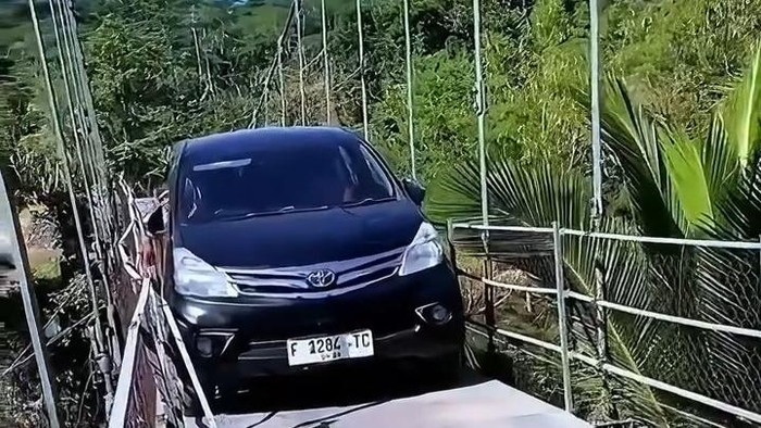 Minibus seberangi sungai dengan jembatan gantung
