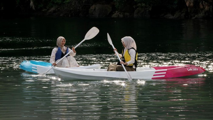 Sejumlah wisatawan bersiap menaiki papan selancar dayung (paddle board) di Danau Lhok Gaca, Aceh Besar, Aceh, Minggu (12/7/2026). Danau berair jernih yang diapit tebing batu dan berbatasan langsung dengan laut tersebut menjadi salah satu destinasi wisata alam di Aceh Besar yang menawarkan aktivitas paddle board dengan jumlah pengguna sekitar 70 hingga 120 orang per hari saat musim liburan. ANTARAFOTO/Akramul Muslim/bar