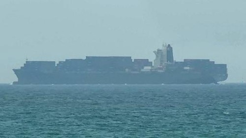 This frame grab taken from AFPTV video footage on July 12, 2026 shows a cargo ship anchoring near the Strait of Hormuz off the eastern coast of the United Arab Emirates at Khor Fakkan. Tehran announced it was closing the Strait of Hormuz on July 12 and launched missiles and drones at its Gulf neighbours, in retaliation for new US strikes following an attack by Iranian forces on a merchant vessel that was abandoned in flames by its crew. (Photo by AFPTV / AFP) / Attention editors: AFP covers the war in the Middle East through its extensive regional network, including bureaus in Tehran, Jerusalem and several neighboring countries.Since the start of the conflict, journalists have been working under increasingly restrictive conditions. Authorities in several countries have limited reporters movements, photo and live video coverage from sensitive locations. Some governments and armed groups have banned images of missile or drone strikes and other security-related sites. /