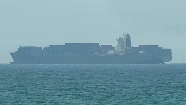 This frame grab taken from AFPTV video footage on July 12, 2026 shows a cargo ship anchoring near the Strait of Hormuz off the eastern coast of the United Arab Emirates at Khor Fakkan. Tehran announced it was closing the Strait of Hormuz on July 12 and launched missiles and drones at its Gulf neighbours, in retaliation for new US strikes following an attack by Iranian forces on a merchant vessel that was abandoned in flames by its crew. (Photo by AFPTV / AFP) / Attention editors: AFP covers the war in the Middle East through its extensive regional network, including bureaus in Tehran, Jerusalem and several neighboring countries.Since the start of the conflict, journalists have been working under increasingly restrictive conditions. Authorities in several countries have limited reporters movements, photo and live video coverage from sensitive locations. Some governments and armed groups have banned images of missile or drone strikes and other security-related sites. /