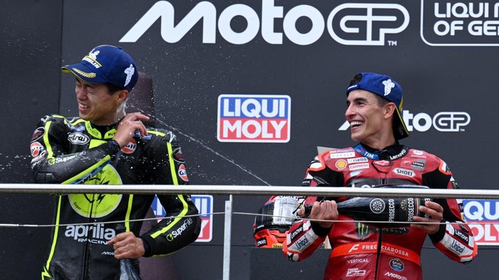 MotoGP - German Grand Prix - Sachsenring, Hohenstein-Ernstthal, Germany - July 12, 2026 Ducati Lenovo Teams Marc Marquez celebrates on the podium after winning the MotoGP race along with runner up Trackhouse MotoGP Teams Ai Ogura REUTERS/Annegret H