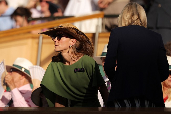 Penampilan itu dipadukan dengan tas DeMellier Nano Montreal warna toffee, sepatu pumps emas Ralph Lauren Celia, anting Van Cleef & Arpels, serta gelang emas Halcyon Days. Kate kembali mengenakan pin pita hijau-ungu AELTC sebagai pelengkap penampilannya. (Foto: REUTERS/Marko Djurica)