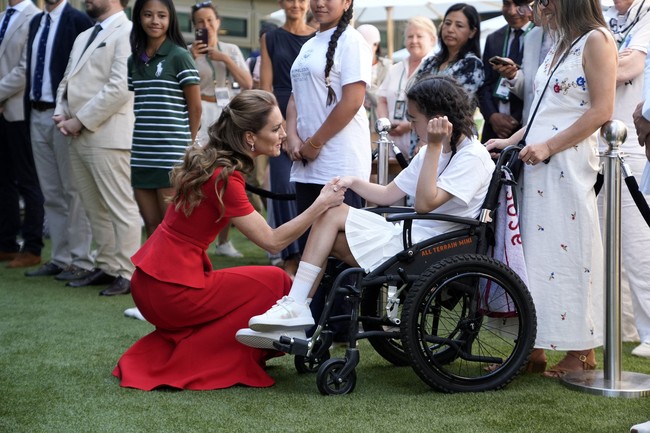 Warna merah yang mencolok menjadi pilihan yang berbeda dari palet busana Wimbledon yang biasanya identik dengan nuansa putih, hijau, atau pastel. Meski tampil berani, keseluruhan look tetap terlihat klasik berkat siluet minimalis khas Roland Mouret. (Foto: Andrew Matthews/Pool via REUTERS)