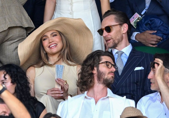 Wanita yang akrab disapa J.Lo ini tampil mengenakan busana Ralph Lauren dari ujung kepala hingga kaki. Ia memilih gaun tanpa lengan berbahan georgette dengan detail bodice crepe yang lembut, dipadukan dengan ikat pinggang senada yang menjuntai sedikit di atas lutut. Foto: WireImage/Karwai Tang