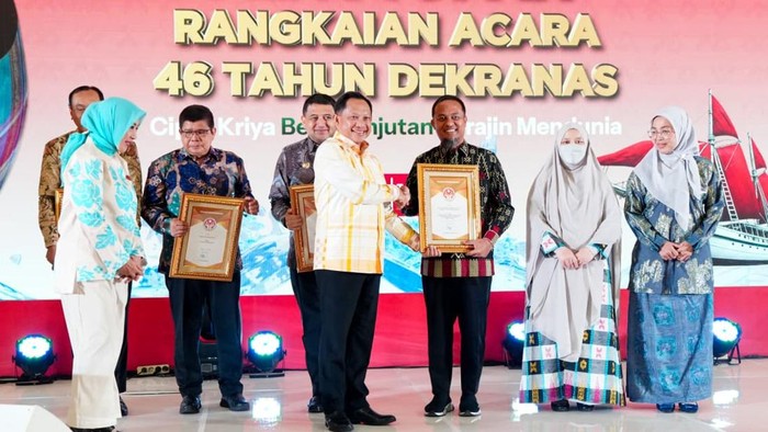 Mendagri Tito Karnavian menyerahkan penghargaan kepada Gubernur Sulsel Andi Sudirman saat acara Syukuran ke-46 Tahun Dekranas.