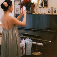 Ariel tampil simpel kenakan dress tali spaghetti berpotongan longgar warna silver. Rambutnya tampak rapih tersanggul, lengkap dengan hiasan bunga berwarna oranye dan krem. Foto: Instagram/@arieltatum