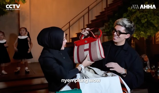 Atta juga memberikan tas dari merek mewah Hermes. Diketahui salah satu tas Hermes tersebut merupakan edisi Herbag Zip 31 laquered bag in H Plume canvas, Hunter cowhide and lacquer, harganya sekitar Rp 61,2 juta. Foto: YouTube/AH2-THE ATTA FAMILY