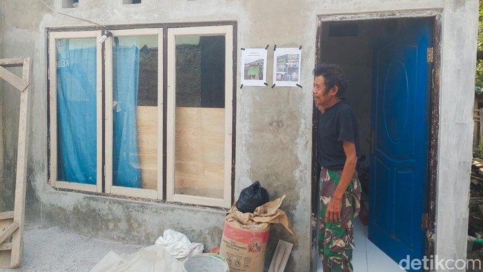 Warga penerima bantuan rutilahu pemkab bandung barat menunjukkan bagian luar rumah yang diperbaiki