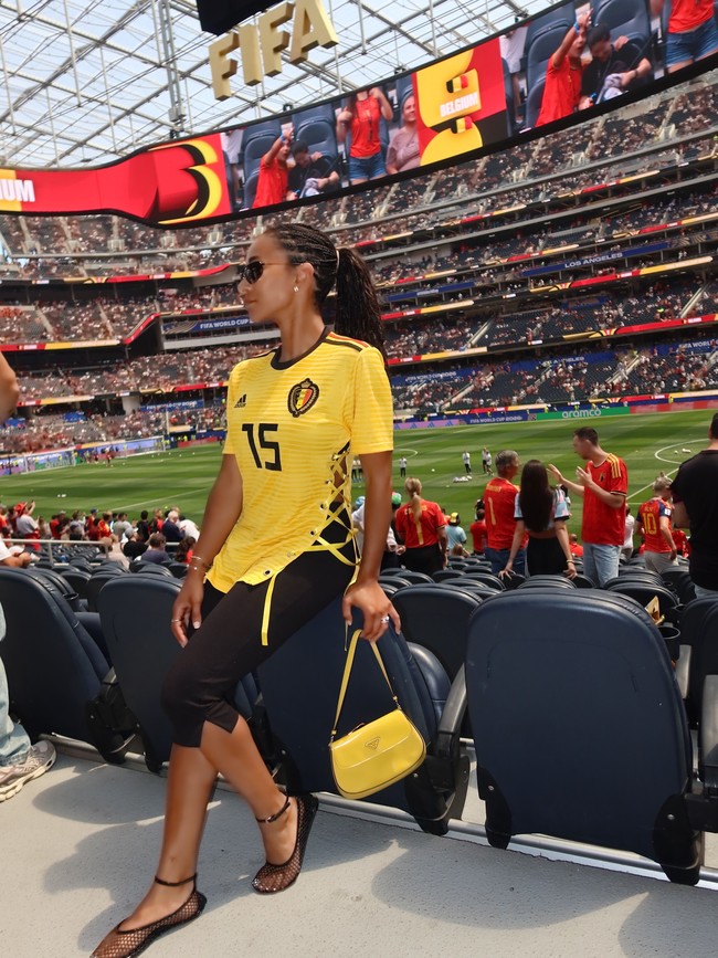 Kemewahan yang lebih refined ditampilkan Deborah Panzokou, istri Thomas Meunier. Ia memilih jersey Belgia yang dimodifikasi dengan detail side lacing bergaya korset sehingga siluetnya tampak lebih feminin. Tas Prada serta aksesori minimalis melengkapi keseluruhan penampilan tanpa terlihat berlebihan. Hasil akhirnya terasa elegan dan mewah, meski belum cukup ikonis untuk menjadi salah satu fashion statement yang paling dikenang dari turnamen ini. (Foto: Instagram)