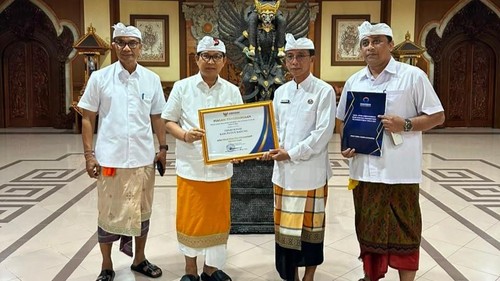 Bupati Wayan Adi Arnawa saat menyerahkan Piagam Penghargaan kepada Kadis Sosial Badung I Gde Eka Sudarwitha di Puspem Badung. (Pemkab Badung)