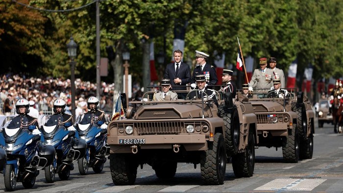 French President Emmanuel Macron stands in the command car with General Chief of Staff of the French Armed Forces Fabien Mandon during the annual Bastille Day military parade on the Champs-Elysees avenue in Paris, France, July 14, 2026. REUTERS/Benoit Tessier/Pool