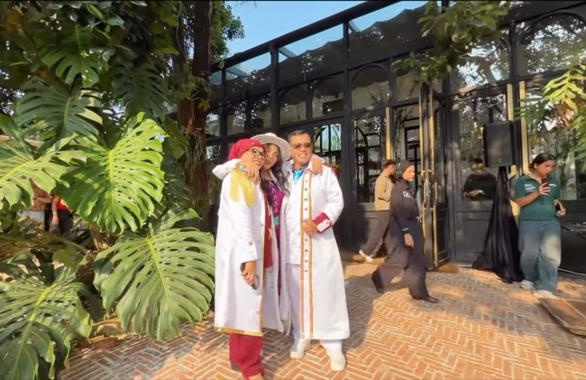 Penampilan Fuji terlihat kompak dengan ayah ibunya, Dewi Zuhriati dan Haji Faisal, yang juga mengenakan coat putih panjang. Foto: Instagram/@fuji_an