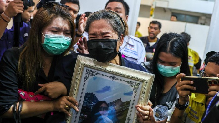 Family members react as they receive the body of a victim at the Police Hospital morgue, following a deadly fire at a pub in Bangkok, Thailand, July 14, 2026. REUTERS/Athit Perawongmetha