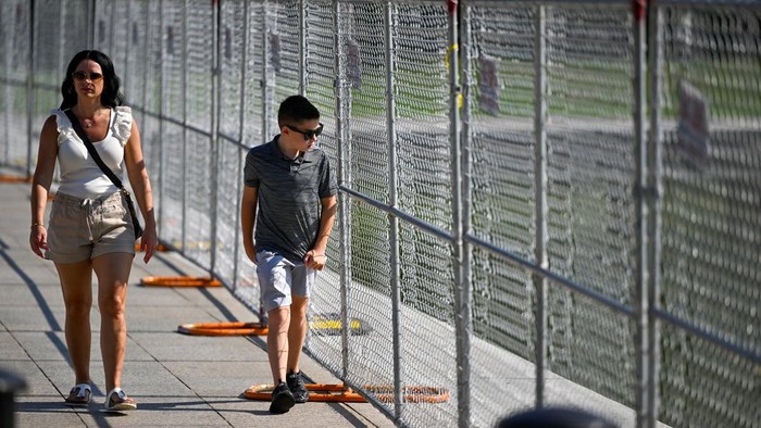 People gather near fencing surrounding the Lincoln Memorial Reflecting Pool on the National Mall in Washington, D.C., U.S., July 11, 2026. REUTERS/Daniel Heuer