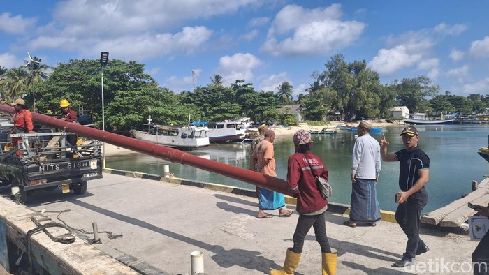 Proses bongkar muat tiang listrik di pelabuhan Pagerungan kecil