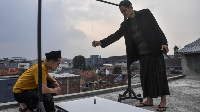 Pengurus DKM Al Wasilah mengukur arah kiblat menggunakan alat tradisional di area terbuka lantai atas bangunan di Kampung Cintarasa, Kota Tasikmalaya, Jawa Barat, Rabu (15/7/2026). Kementerian Agama mengajak umat Islam memanfaatkan fenomena Rashdul Kiblat, saat Matahari tepat berada di atas Ka'bah, untuk memastikan arah kiblat rumah dan tempat ibadah secara akurat tanpa alat khusus yang hanya terjadi dua kali dalam setahun. ANTARA FOTO/Adeng Bustomi/