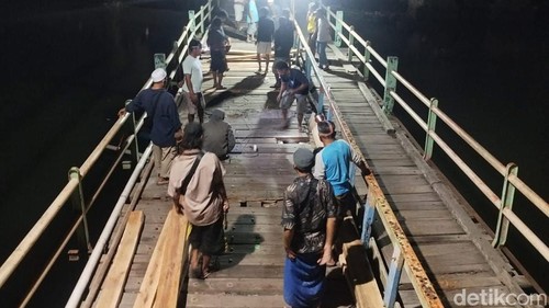 Warga bergotong royong memperbaiki Jembatan Cemare di Desa Lembar Selatan, Kecamatan Lembar, Lombok Barat, Selasa (14/7/2026).
