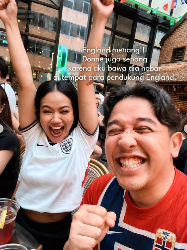 Yura juga terlihat ikut nobar Piala Dunia Inggris melawan Norwegia. Kali ini Yura memilih mengenakan jersey Inggris berwarna putih. Lagi-lagi, sang suami diminta Yura untuk mengenakan jersey lawan, Norwegia, yang diprediksi akan kalah. Foto: Instagram/@yurayunita