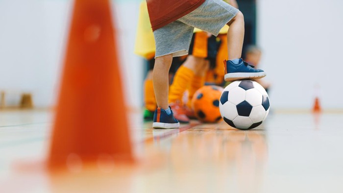 Kids Indoor Soccer Training. Children Practicing Football Skills with Ball and Cones in Sports Hall