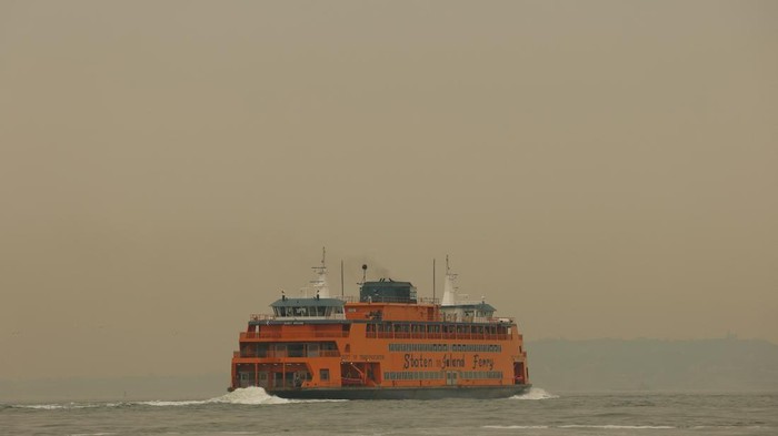 Ferry boats cross New York Harbor, seen through a cover of wildfire smoke, in New York City, U.S., July 16, 2026. REUTERS/Mike Segar