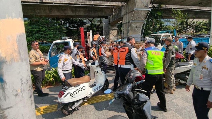 Petugas angkut motor yang parkir di trotoar, Kuningan, Jaksel