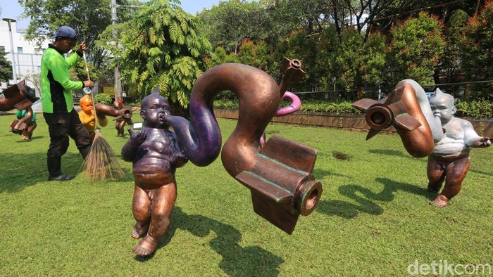 Warga melintas di antara instalasi karya seni Jakarta Provoke! di Taman Menteng, Jakarta, Kamis (16/7/2026). Pameran ruang publik tersebut menghadirkan karya kolektif puluhan seniman dan kurator Jakarta.