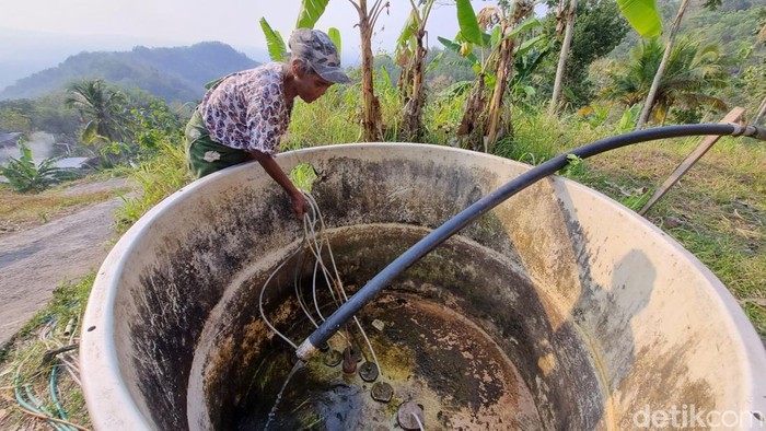 Warga menyedot selang dari bak penampungan air di Bonpon, Pundungsari, Semin, Gunungkidul, Kamis (16/7/2026).