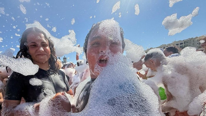 Egyptians and tourists enjoy a cold-foam and bubbles party on the beach, as temperatures soar during a heatwave, at a Red Sea resort in Hurghada, Egypt, July 16, 2026. Picture taken with a mobile phone. REUTERS/Amr Abdallah Dalsh