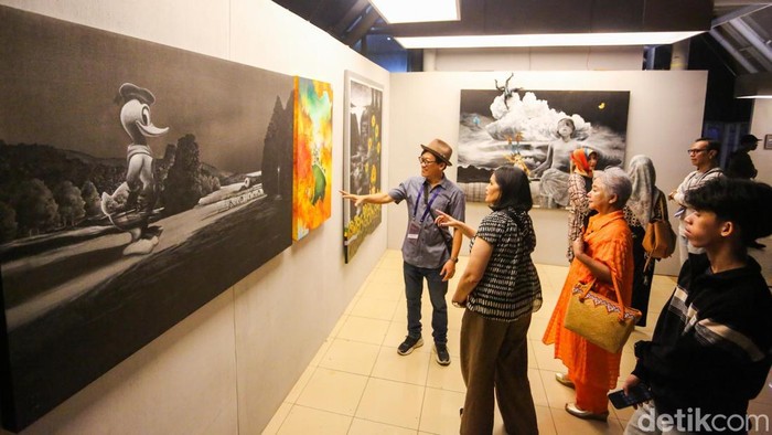 Pengunjung mengamati karya seni dalam pameran Jakarta Provoke! di Taman Menteng, Jakarta, Jumat (17/7/2026).