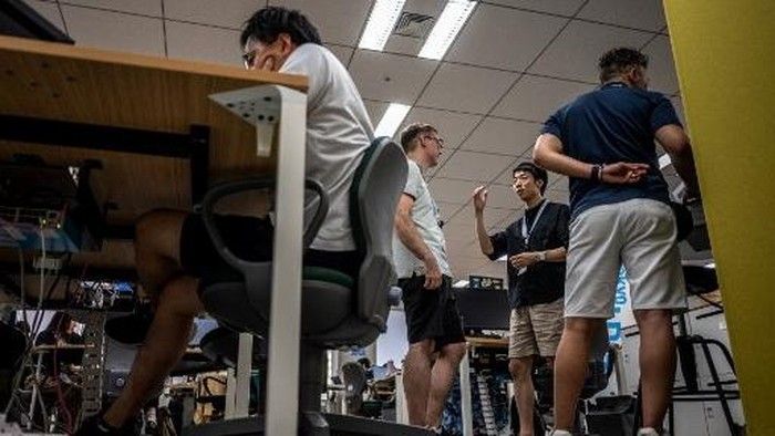 Government officials in casual dress code, including shorts, tee shirts and sneakers, work in the office of the Tokyo Metropolitan Government building, as part of the capitals Cool Biz initiative, in Tokyo on July 14, 2026. (Photo by Philip FONG / AFP)