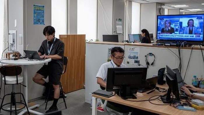Government officials in casual dress code, including shorts, tee shirts and sneakers, work in the office of the Tokyo Metropolitan Government building, as part of the capitals Cool Biz initiative, in Tokyo on July 14, 2026. (Photo by Philip FONG / 