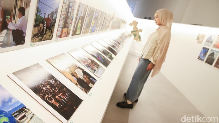 Pengunjung mengamati karya dalam pameran fotografi Awan Cerah di Galeri Emiria Soenassa, Taman Ismail Marzuki, Jakarta, Jumat (17/7/2026). Pameran ini menampilkan karya anak-anak sebagai ruang berekspresi melalui media visual.