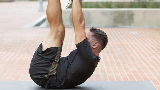 Toe touches Young and attractive man doing fitness in outdoor park
