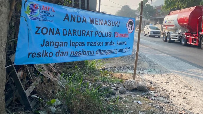 Warga memasang spanduk protes polusi debu batu kapur di Ccipatat, Bandung Barat.