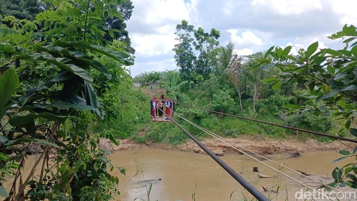 Anak-anak di Kutai Kartanegara pulang sekolah menggunakan kereta gantung melintasi sungai.