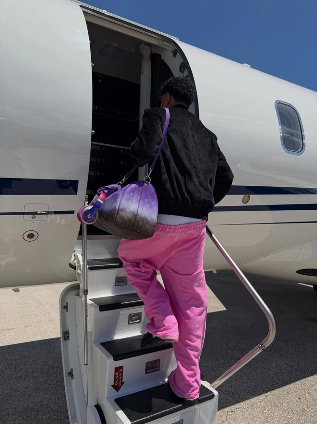 Pria 19 tahun ini juga penggemar berat tas-tas keluaran Louis Vuitton, khususnya Keepall yang ukurannya sangat pas bagi individu sepertinya yang intens bepergian. Apalagi tas model dufflebag yang dipakai Lamine ini merupakan versi Bandouliere yang hadir dalam warna ungu bergradasi yang matching dengan baju-bajunya yang selalu colorful.  (Foto: Instagram/@lamineyamal)