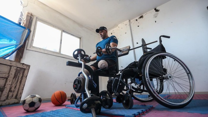 GAZA CITY, GAZA - JULY 18: Allam Mohammed Shabir, 36, training inside his home on July 18, 2026 in Gaza City, Gaza. Allam Mohammed Shabir, 36, from the beach camp for Palestinian refugees, is a former player of the Beach Services Club and the Friendship Sports Club, whose feet were amputated after he was injured by Israeli attacks during the war in the Gaza Strip in 2025. He worked to establish a sports room for training inside his home to rebuild his body as he recovered from his wounds. He worked to collect sports equipment with difficulty due to the destruction of clubs and gyms during the war. Allam aspires to participate in international forums and championships. (Photo by Ahmad Hasaballah/Getty Images)