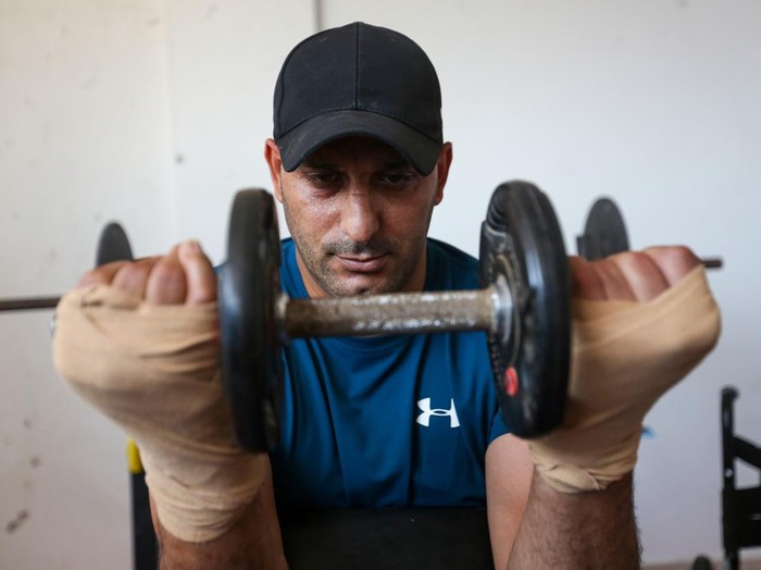 GAZA CITY, GAZA - JULY 18: Allam Mohammed Shabir, 36, training inside his home on July 18, 2026 in Gaza City, Gaza. Allam Mohammed Shabir, 36, from the beach camp for Palestinian refugees, is a former player of the Beach Services Club and the Friendship Sports Club, whose feet were amputated after he was injured by Israeli attacks during the war in the Gaza Strip in 2025. He worked to establish a sports room for training inside his home to rebuild his body as he recovered from his wounds. He worked to collect sports equipment with difficulty due to the destruction of clubs and gyms during the war. Allam aspires to participate in international forums and championships. (Photo by Ahmad Hasaballah/Getty Images)