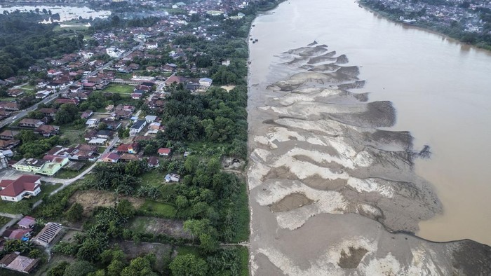 Foto udara permukiman dan hamparan pasir di pinggir Sungai Batanghari yang surut di Tanjung Pasir, Danau Teluk, Jambi, Sabtu (18/7/2026). Sungai terpanjang di Sumatera itu mulai menyusut dan memunculkan hamparan pasir hingga seluas lima hektare lebih di sejumlah titik meliputi Kota Jambi, Kabupaten Muaro Jambi, dan Batang Hari akibat kemarau yang terjadi sejak dua bulan terakhir. ANTARA FOTO/Wahdi Septiawan/sgd