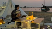 Sebelum malam larut, Sajidah Halilintar sempat mengabadikan momen dengan latar belakang pemandangan matahari terbenam. Duduk santai di depan tenda teepee putih, suasana aesthetic picnic ini semakin lengkap dengan dekorasi meja kayu, lilin, dan sebuah perahu tradisional yang bersandar di tepi laut. (Foto: dok Instagram sajidahhalilintar)