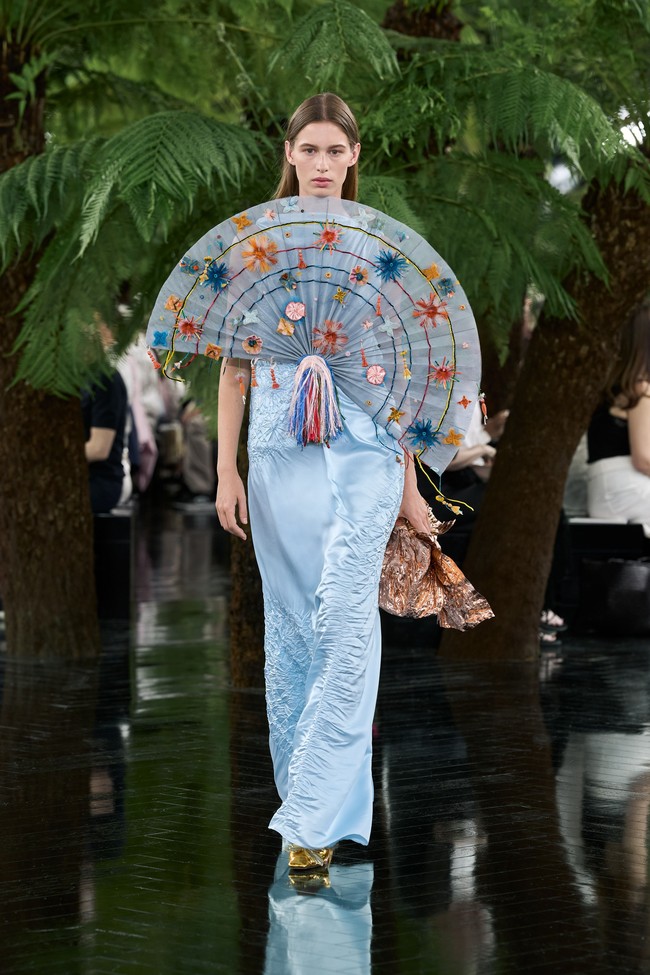 Pengaruh India menjadi benang merah lain dalam koleksi ini. Hubungan panjang Lynda Benglis dengan Ahmedabad, Gujarat, menginspirasi sejumlah detail busana. Seri karya Peacock yang mulai ia kerjakan sejak akhir 1970-an diterjemahkan melalui aplikasi bunga berwarna cerah dan detail beadwork yang menghiasi beberapa tampilan. (Foto: Dok. Christian Dior)