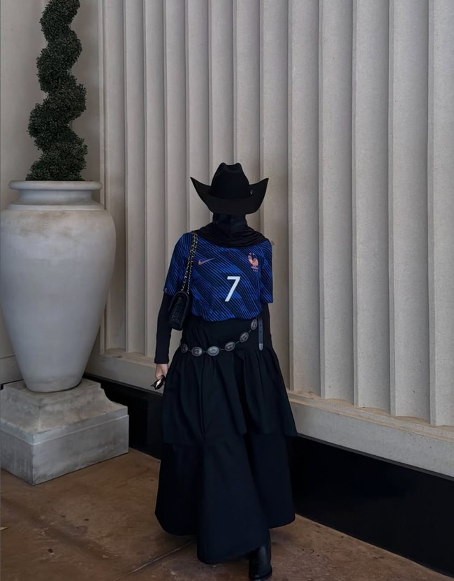 Rima tampil memakai jersey Prancis warna biru dengan nomor 7 milik suaminya. Dia memadukannya dengan busana serba hitam mulai dari ujung kaki hingga kepala. Sepatu, topi, tas, rok hingga hijab yang dikenakanannya semua warna hitam. Foto: Dok. Instagram rima.edbouche