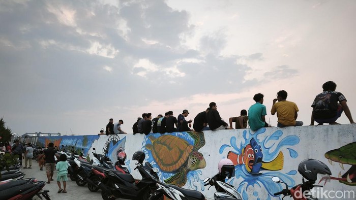 Pemandangan tanggul laut yang bersolek mural dan lokasi memburu senja di Kampung Tambak Lorok, Kecamatan Semarang Utara, Kota Semarang, Sabtu (18/7/2026)