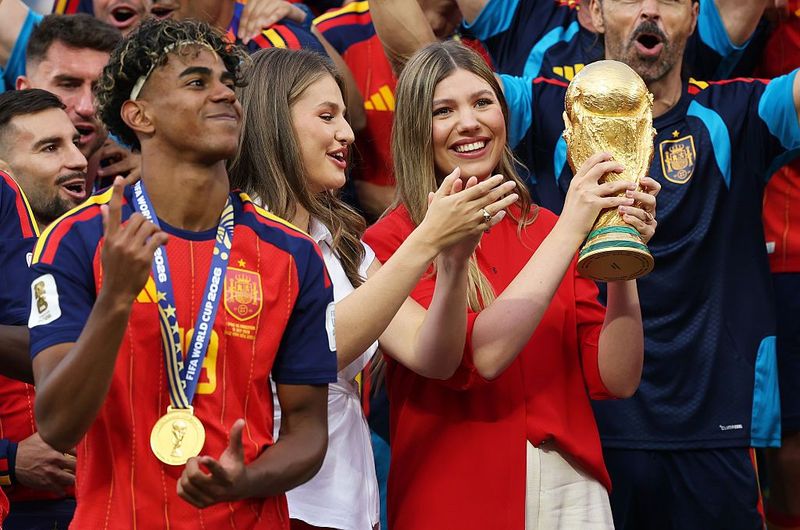 EAST RUTHERFORD, NEW JERSEY - JULY 19: Princess Sofia of Spain lifts the trophy while Princess Leonor of Spain and Lamine Yamal #19 of Spain watch at the award ceremony following the FIFA World Cup 2026 Final match between Spain and Argentina at New York New Jersey Stadium on July 19, 2026 in East Rutherford, New Jersey. (Photo by Carl Recine/Getty Images)